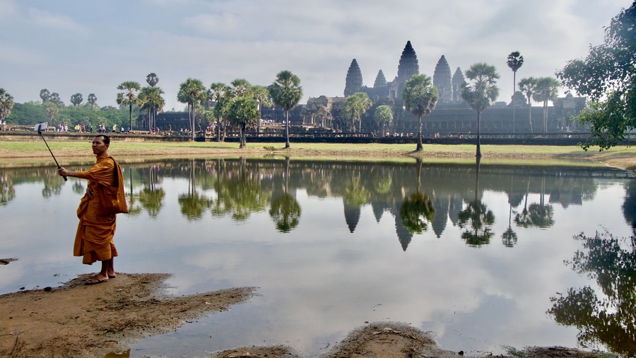 Monk posing for selfie in front of Angkor Wat