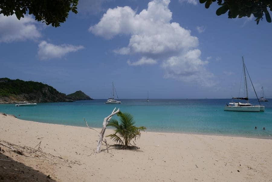 Beach view of St Barths with sailboats and turquoise waters.